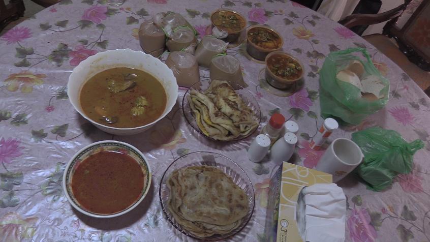 A stack of roti chanai, chicken curry, and chutney.
