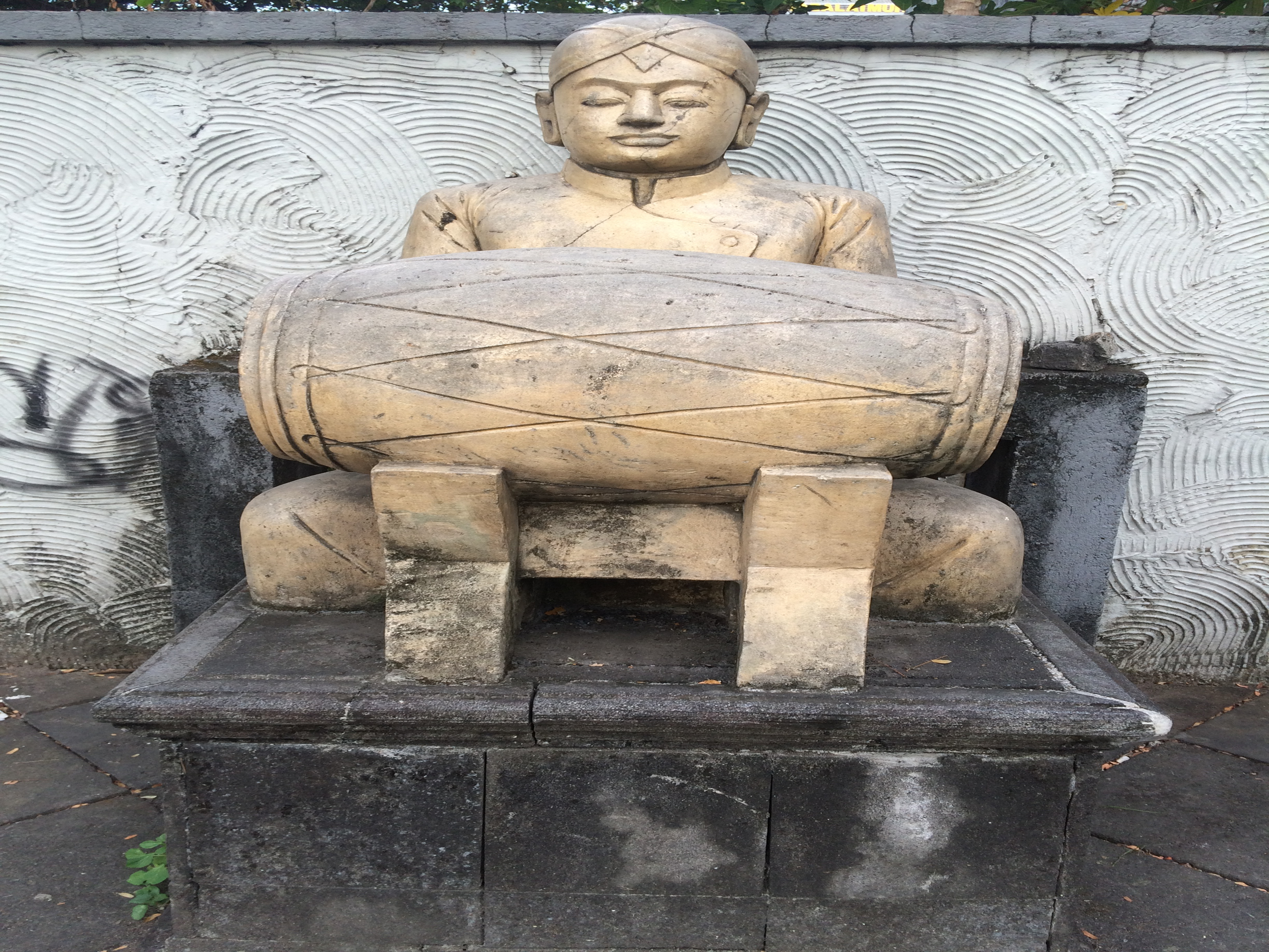 Sculpture of a man playing kendang.
