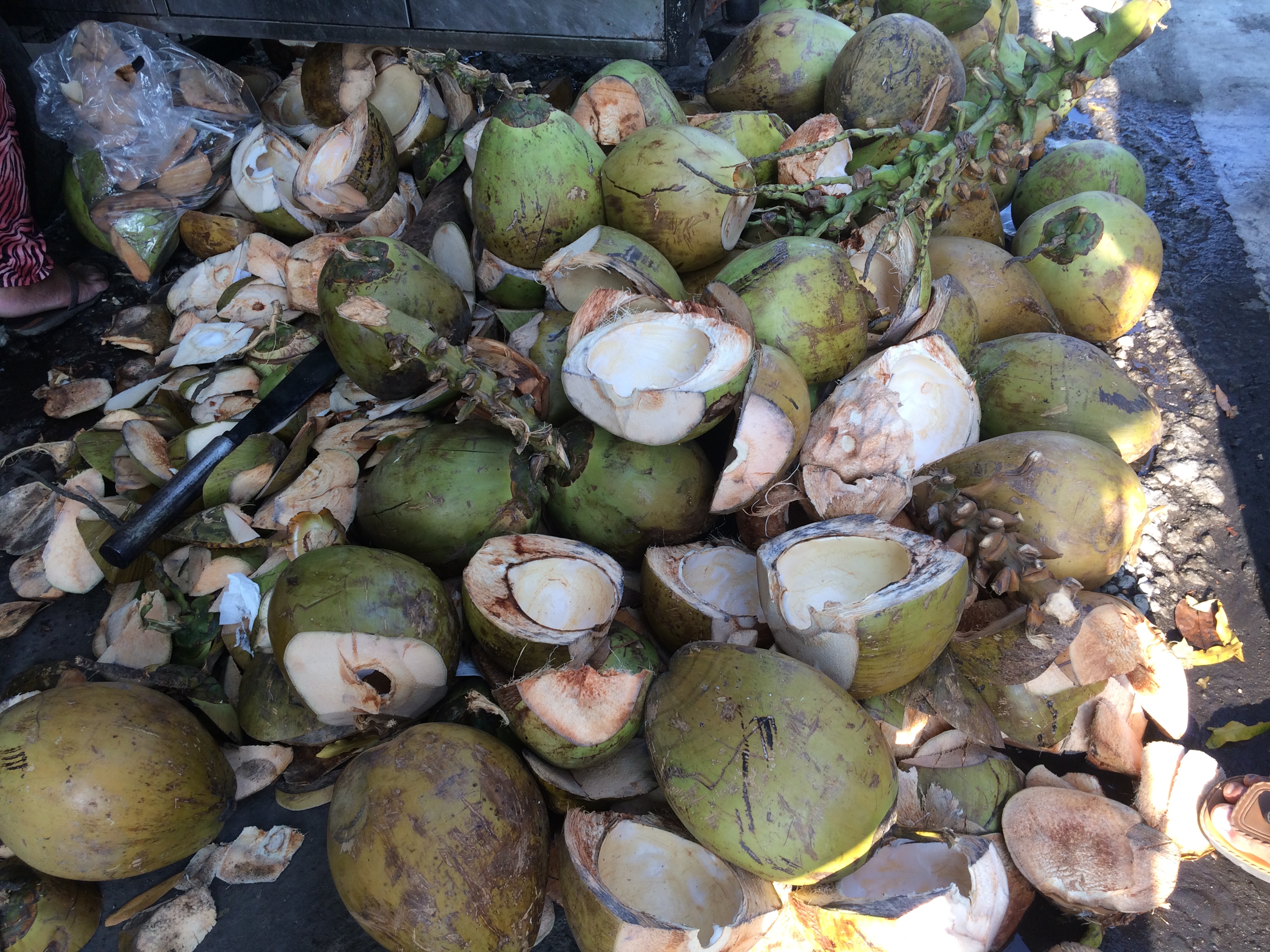 Coconuts beside a streetside coconut water vendor.